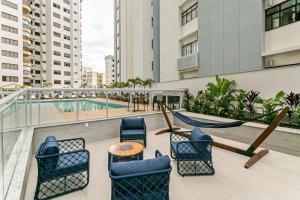 balcón con sillas, mesa y piscina en Vista parcial do MAR em ótima localização #CA24, en Florianópolis