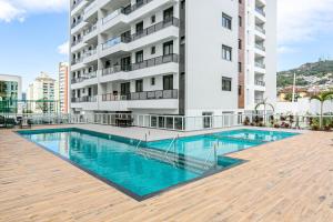 una piscina frente a un edificio en Vista parcial do MAR em ótima localização #CA24, en Florianópolis