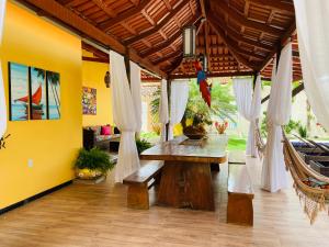 Villa Paradise in Brazil - Praia de Guaratiba Prado-BA في برادو: غرفة طعام مع طاولة وكراسي خشبية