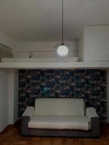 a white couch in a room with a wall at Alloggio incantevole/ bedsitting-room in Altavilla Milicia