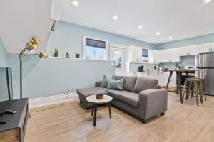 a living room with a couch and a kitchen at Bright and Spacious Condo in Downtown Collingwood 97043 in Collingwood