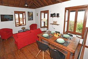 ein Wohnzimmer mit einem Tisch und einer roten Couch in der Unterkunft Casa La Florida in Puntagorda