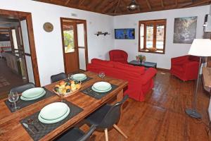 ein Wohnzimmer mit einem Tisch und einer roten Couch in der Unterkunft Casa La Florida in Puntagorda