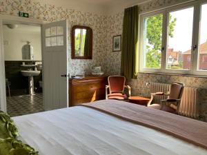 Un dormitorio con una cama grande y un baño. en Tree & B, en Brujas