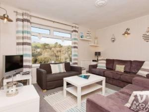 a living room with a couch and a tv at Harbour View in Kingswear