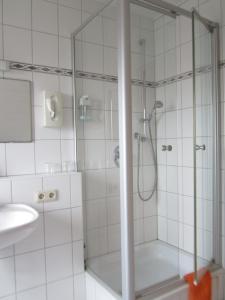 a shower with a glass door in a bathroom at Hotel Waldparkstube in Bad Schonborn