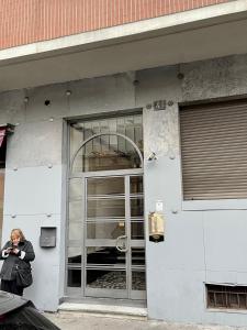 una mujer está parada fuera de un edificio en Enzo en Milán