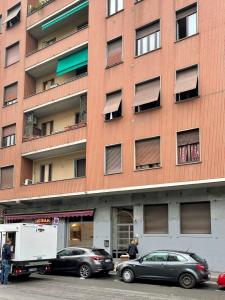 ein großes Backsteingebäude mit davor geparkt in der Unterkunft Enzo in Mailand