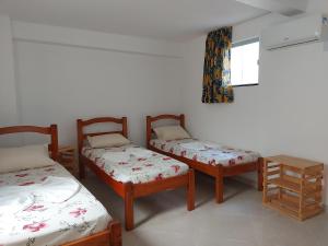 um quarto com três camas e uma janela em Casarão Nazaré Hostel em Salvador