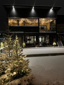 a house with a christmas tree in the snow at Villa Log modern interior in Rovaniemi