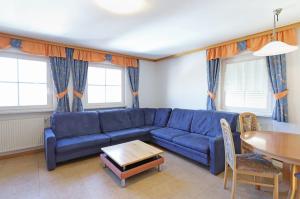 ein Wohnzimmer mit einem blauen Sofa und einem Tisch in der Unterkunft Residence Sonneck in Martell