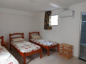 a room with two twin beds and a window at Casarão Nazaré Hostel in Salvador