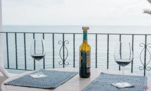 een fles wijn zittend op een tafel met twee wijnglazen bij Aldeas Taray Admer 002 in La Manga del Mar Menor