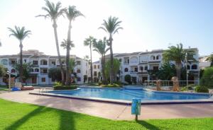 een resort met een groot zwembad en palmbomen bij Aldeas Taray Admer 002 in La Manga del Mar Menor