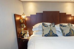 een hotelkamer met een bed met blauwe en witte kussens bij Ocean Mist Leith in Edinburgh