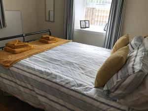 a bedroom with a bed with towels on it at Curlew Cottage and Sunset View 