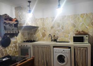 y cocina con fogones y lavadora. en Casa Rural Villa Sargento en Níjar