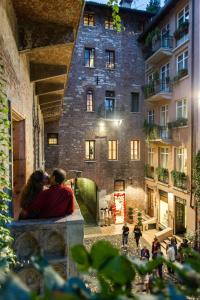 a man and woman kissing in front of a building at La Corte Di Giulietta in Verona