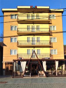 un gran edificio amarillo con balcones. en EDO'S, en Borşa