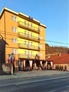 un edificio amarillo con balcones en el lateral de una calle en EDO'S, en Borşa