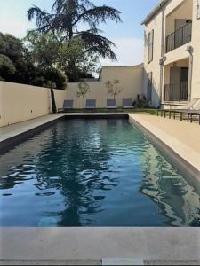 a swimming pool in front of a building at Les Cyclistes : appartement Vintoux in Malaucène