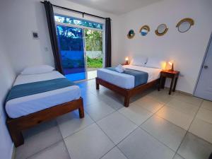 a bedroom with two beds and a large window at VIVE El VALLE Hotel in El Valle