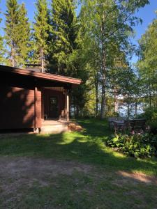 eine kleine Hütte mit einer Bank im Hof in der Unterkunft Vehkaniemen Lomatila in Pohjaslahti