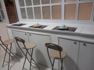 a kitchen with stools and a counter with dishes at Wendy House Apartament in Bari