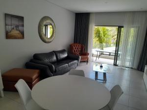 格蘭貝伊的住宿－Joli appartement neuf 2ch 2sdb 50m de la mer，客厅配有桌子和沙发