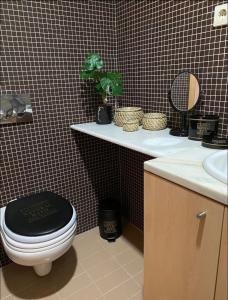 a bathroom with a toilet and a sink and a mirror at Lovely Apartment at Quinta da Portela - Coimbra in Coimbra
