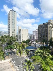 Free parking Comfy central Waikiki في هونولولو: أفق المدينة مع المباني الطويلة وأشجار النخيل