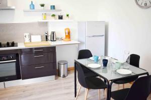 une cuisine avec une table et des chaises dans l'établissement Appartements cosy Audincourt - direct-renting ''renting with good vibes'', à Audincourt