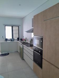 a kitchen with a sink and a stove top oven at Joli appartement neuf 2ch 2sdb 50m de la mer in Grand-Baie