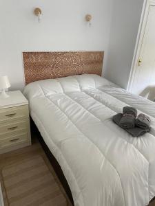 un letto bianco con due paia di scarpe sopra di A&C Algarrobo costa - Malaga a Algarrobo-Costa