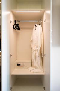 a closet with a white robe and a appliance at Luxury Apt - Rooftop Pool - City View in Dubai