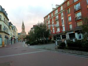 una calle de ciudad vacía con una torre de reloj en la distancia en Agréable maison de ville En plein cœur de Rouen en Rouen