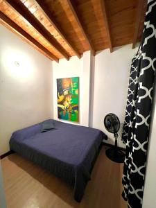 ein Schlafzimmer mit einem lila Bett in einem Zimmer in der Unterkunft Cómodo apartamento completo en Envigado in Envigado