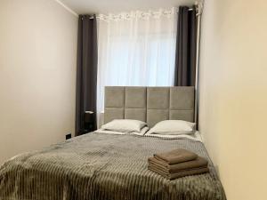 a bedroom with a bed with two towels on it at Apartament Marina Hel in Hel