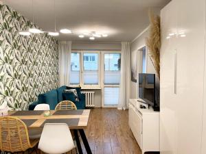 een woonkamer met een blauwe bank en een televisie bij Apartament Marina Hel in Hel