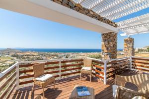 a balcony with chairs and a view of the ocean at Epsilon Villa by TinosHost in Tinos Town