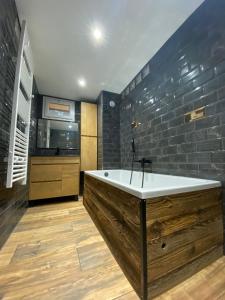a bathroom with a large bath tub and a kitchen at Lautaret 5 G0 in Les Deux Alpes