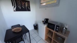 a small kitchen with a table and a microwave at Adorable studio avec entrée indépendante in Dijon