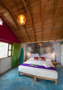 a bedroom with a large bed and a wooden ceiling at Hotel Pochote Mazunte in Mazunte
