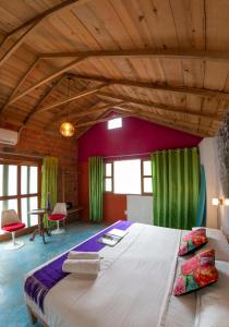 una camera da letto con un grande letto con tende verdi di Hotel Pochote Mazunte a Mazunte