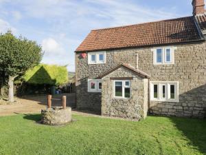 une maison en pierre avec une cour devant elle dans l'établissement 26 Tansey, à Shepton Mallet