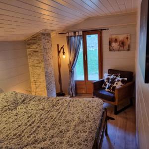 a bedroom with a bed and a chair and a window at Le Passage in Salvan