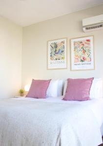 1 dormitorio con 1 cama blanca grande con almohadas moradas en Recoleta Apartment Amazing view -13A- en Buenos Aires