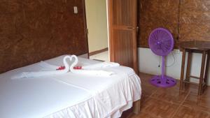 1 dormitorio con cama blanca y ventilador púrpura en Hospedaje el Emperador, en Pucallpa