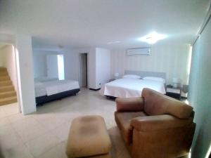 Habitación de hotel con cama, silla y sofá en Hotel Ejecutivo Portoviejo, en Portoviejo