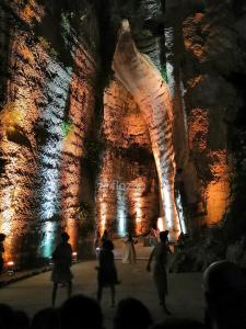 a group of people walking around a cave with lights at Sicilian Panoramic Apartment in Floridia